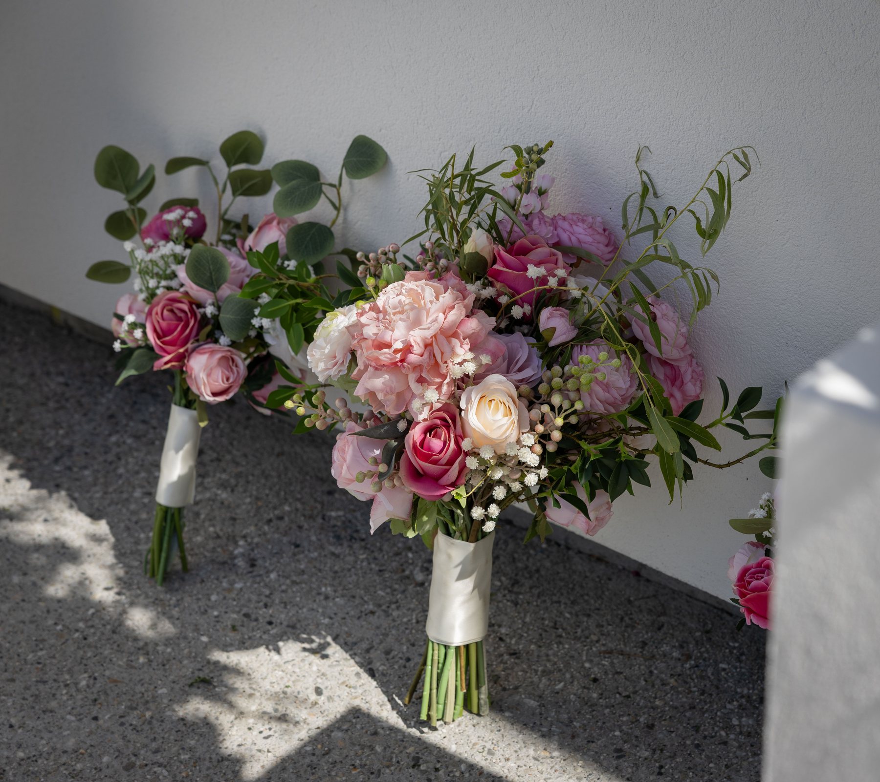 Bridesmaids' posies against a wall